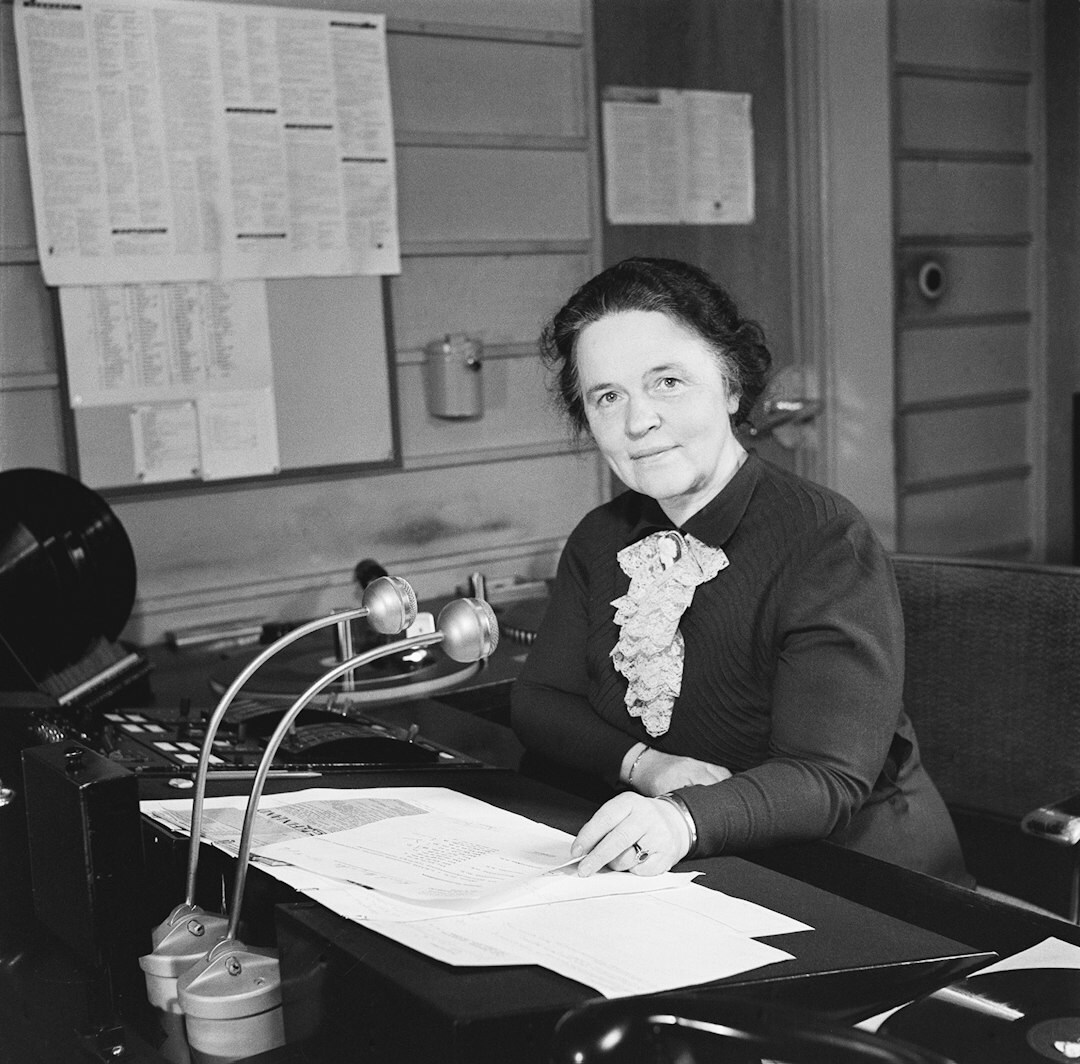 Mujer archivista argentina revisando documentos antiguos en un archivo